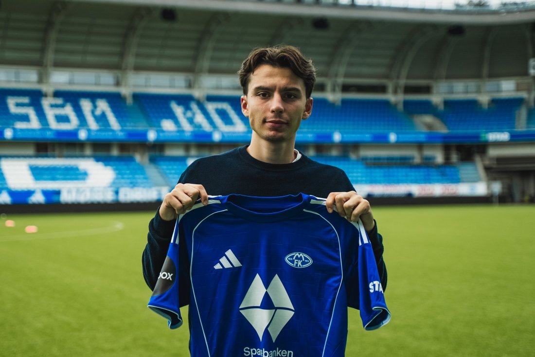 Blerton Isufi holder opp Molde FKs blå hjemmedrakt på Aker Stadion, med tribuner i bakgrunnen, etter å ha signert for klubben sommeren 2025.