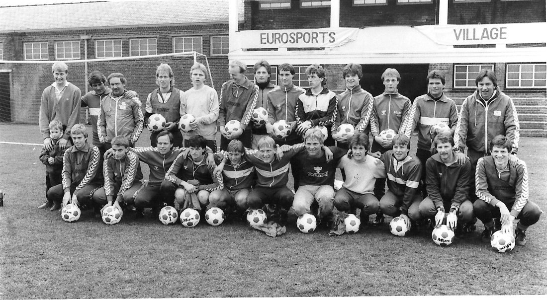 Treningsleir i England. Bak f.v: Åge Hareide med godt tak rundt sønnen Bendik, Bernt Roald, Svein Ivar Melsæther, Rune Ulvestad, Ulrich Møller, Steinar Henden, Ove Heggem, Knut Hallvard Eikrem, Bjørnar Mykning, Tore Jermstad, Lars Tore Brandeggen, Per Arne Aase, Jan Fugleset. Foran f.v.: Tor Gunnar Hagbø, Stig Monsen, Stein Olav Hestad, Terje Sorthe, Jan Berg, Knut Nesbø, Alf Dahl, Børre Bjørsvik, Geir Malmedal, Inge Bratteteig, Bertil Stranden.