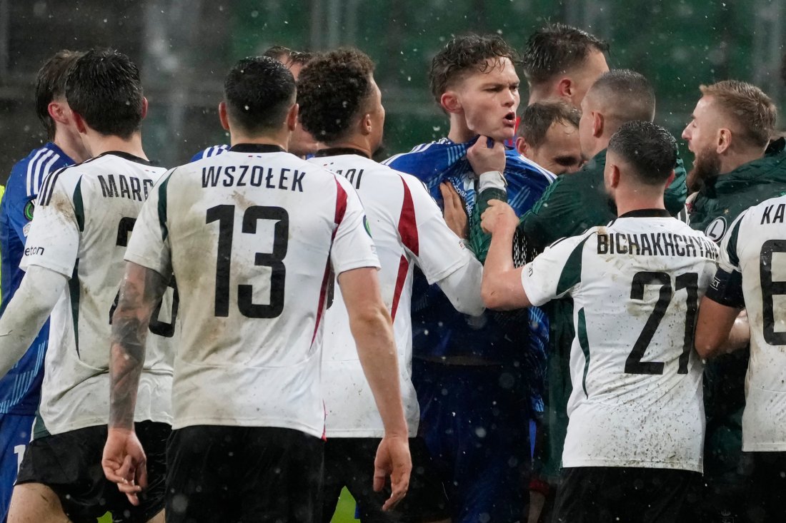 Gustav Kjølstad Nyheim lar seg ikke stoppe av en skokk Legia-spillere fra både bane og benk. Foto: Czarek Sokolowski / AP/NTB